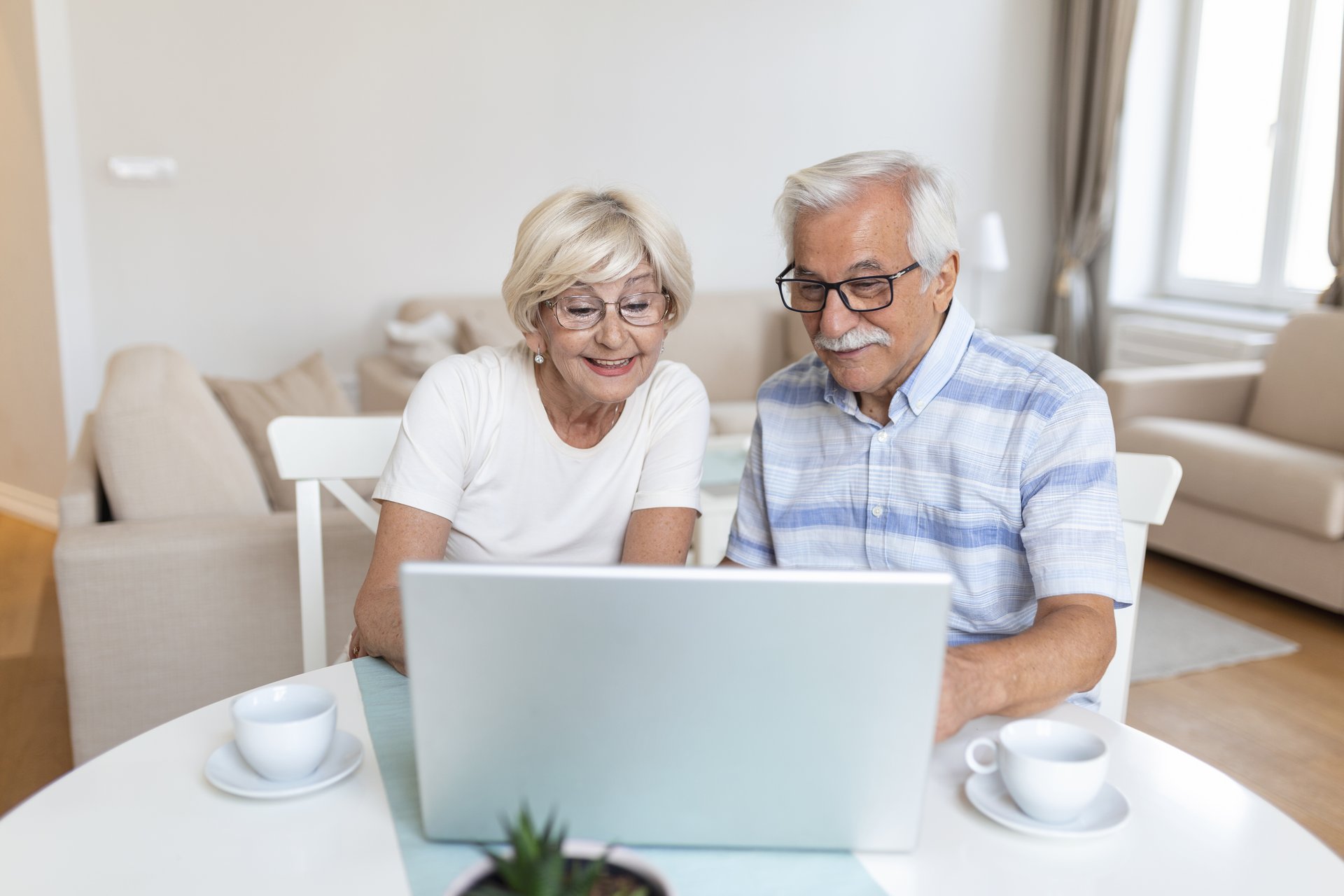 Senior couple is talking online via video connection on the laptop. Having nice time withfriends and family via video call.