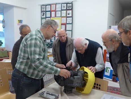 In dem Repair-Cafe der Caritas reparieren Personen ein Elektrogerät